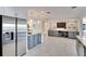 Open-concept kitchen with stainless steel refrigerator and gray cabinets leading to a living area with built-in shelves at 805 Leisey Cir, Ruskin, FL 33570