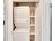 Laundry closet features a stacked washer and dryer with built-in shelving at 805 Leisey Cir, Ruskin, FL 33570