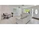 Bright living room with neutral colors, ceiling fan, and entryway view at 805 Leisey Cir, Ruskin, FL 33570