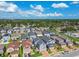 This aerial view showcases a neighborhood with many two-story homes, tree-lined streets and beautiful blue skies at 8148 Artisan Cir, Seminole, FL 33777