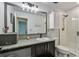 Updated bathroom featuring a granite countertop, decorative lighting, and a shower with tiled walls at 8148 Artisan Cir, Seminole, FL 33777