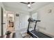 A bedroom featuring a treadmill, a ceiling fan, and a doorway to the bathroom at 8148 Artisan Cir, Seminole, FL 33777