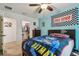 A bedroom featuring a ceiling fan, a walk-in closet, and vibrant superhero-themed decor at 8148 Artisan Cir, Seminole, FL 33777