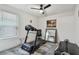 Bedroom featuring a treadmill, a ceiling fan, and a large mirror, creating a functional space at 8148 Artisan Cir, Seminole, FL 33777