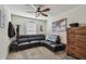 Bonus room with a sleek black leather sofa, a wooden dresser, and a ceiling fan at 8148 Artisan Cir, Seminole, FL 33777