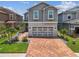 Beautiful gray two-story home with brick paver driveway, a two-car garage, and tropical landscaping at 8148 Artisan Cir, Seminole, FL 33777