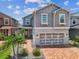 Beautiful gray two-story home with brick paver driveway, a two-car garage, and tropical landscaping at 8148 Artisan Cir, Seminole, FL 33777