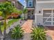 View of the entrance and garage with brick pavers, lush landscaping, and gray stone at 8148 Artisan Cir, Seminole, FL 33777