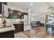 This kitchen boasts dark cabinetry, stainless appliances, granite counters, tile backsplash with open living spaces at 8148 Artisan Cir, Seminole, FL 33777