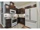 A well-appointed kitchen with stainless steel appliances, granite counters, and dark wood cabinets at 8148 Artisan Cir, Seminole, FL 33777