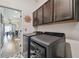 The laundry room features dark cabinets and modern machines near the open concept living and dining area at 8148 Artisan Cir, Seminole, FL 33777
