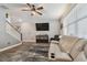 Cozy living room features a ceiling fan, television, a modern rug and a comfortable light colored leather couch at 8148 Artisan Cir, Seminole, FL 33777
