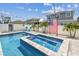 Enjoy a luxurious backyard featuring a pool and spa with brick pavers and a white privacy fence at 8148 Artisan Cir, Seminole, FL 33777
