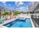 Backyard with a gorgeous in-ground pool and spa, string lights, and a privacy fence at 8148 Artisan Cir, Seminole, FL 33777