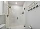 Shower features white tiled walls, modern fixtures, and a glass door at 8148 Artisan Cir, Seminole, FL 33777