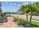 View of the street and neighborhood featuring brick pavers, lush landscaping, and green lawns at 8148 Artisan Cir, Seminole, FL 33777