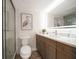 Bathroom featuring shower with glass door, tile floors, stylish vanity with art display and large mirror at 825 S Gulfview Blvd # 104, Clearwater Beach, FL 33767