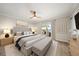 Comfortable bedroom featuring a large bed, ceiling fan, and sliding glass doors to a patio with water views at 825 S Gulfview Blvd # 104, Clearwater Beach, FL 33767
