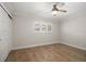 A bright and airy bedroom with hardwood floors, ceiling fan, and a closet with sliding doors at 825 S Gulfview Blvd # 104, Clearwater Beach, FL 33767