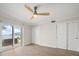 Bedroom with a ceiling fan, sliding glass doors to a patio, and closets with sliding doors at 825 S Gulfview Blvd # 104, Clearwater Beach, FL 33767