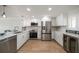 Modern kitchen featuring bright white cabinetry, stainless steel appliances, and stylish bar seating at 825 S Gulfview Blvd # 104, Clearwater Beach, FL 33767