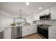 Bright kitchen featuring stainless steel appliances, white cabinets, and marble backsplash, with water views at 825 S Gulfview Blvd # 104, Clearwater Beach, FL 33767