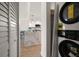 Laundry room with stackable washer and dryer, and view of the kitchen with marble countertop island at 825 S Gulfview Blvd # 104, Clearwater Beach, FL 33767