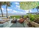 Outdoor patio area with multiple seating arrangements, beautiful water views, and a lemon-themed umbrella at 825 S Gulfview Blvd # 104, Clearwater Beach, FL 33767