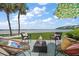 Outdoor patio area with seating, palm trees, and scenic water views, shaded with a lemon umbrella at 825 S Gulfview Blvd # 104, Clearwater Beach, FL 33767