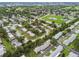 Community aerial view showing homes, landscaping, and nearby golf course and pond at 8319 Annwood Rd, Seminole, FL 33777