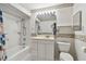 Bathroom with shower-tub combination, white tile, and decorative wallpaper at 8319 Annwood Rd, Seminole, FL 33777