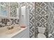 Bathroom showcasing bold black and white wallpaper, a vanity, and linen closet for storage at 8319 Annwood Rd, Seminole, FL 33777