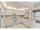 Bright kitchen with white cabinets, appliances, and serving bar at 8319 Annwood Rd, Seminole, FL 33777
