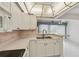 Bright eat-in kitchen with white cabinets, a double sink, and views of the open living space at 8319 Annwood Rd, Seminole, FL 33777