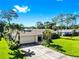 Beautiful home featuring a well-manicured lawn, mature trees, and a spacious two-car garage at 8671 11Th N St, St Petersburg, FL 33702