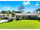 A well kept home features lush green grass and mature trees with a 2-car garage at 8671 11Th N St, St Petersburg, FL 33702