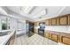 Bright kitchen featuring wooden cabinetry, white countertops and white tile flooring at 8671 11Th N St, St Petersburg, FL 33702