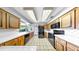 Bright kitchen featuring wooden cabinetry, white countertops and white tile flooring at 8671 11Th N St, St Petersburg, FL 33702