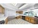Bright kitchen featuring wooden cabinetry, white countertops and white tile flooring at 8671 11Th N St, St Petersburg, FL 33702