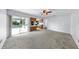 Spacious living room with carpet flooring opens to a screened-in patio and an adjacent kitchen at 8671 11Th N St, St Petersburg, FL 33702