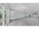 Spacious living room with neutral walls, plush carpet, a ceiling fan, and sliding glass doors to the lanai at 8671 11Th N St, St Petersburg, FL 33702
