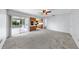 Spacious living room with carpet flooring opens to a screened-in patio and an adjacent kitchen at 8671 11Th N St, St Petersburg, FL 33702
