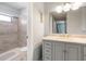 Bathroom featuring gray vanity, tiled shower, and framed mirror with lighting at 9209 Seminole Blvd # 13, Seminole, FL 33772