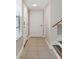 Tiled hallway with stairway and doors, leading to various rooms in the home at 9209 Seminole Blvd # 13, Seminole, FL 33772