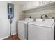 Bright laundry room with white washer, dryer, storage cabinets, and vacuum cleaner at 9209 Seminole Blvd # 13, Seminole, FL 33772