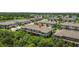 Aerial view of modern townhomes surrounded by mature trees and picturesque water features with red pin on the property at 9768 Pembrooke Pines Dr, Sun City Center, FL 33573