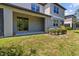 Backyard featuring green grass, small garden with shrubbery, and sliding glass door at 9768 Pembrooke Pines Dr, Sun City Center, FL 33573