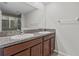 Bathroom with double sink vanity, granite countertop, and large mirror at 9768 Pembrooke Pines Dr, Sun City Center, FL 33573