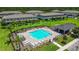 Aerial view of a sparkling community pool surrounded by lush landscaping and comfortable lounge seating at 9768 Pembrooke Pines Dr, Sun City Center, FL 33573