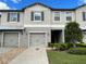 Beautifully maintained townhome featuring an attached garage, well-manicured lawn and front yard landscaping at 9768 Pembrooke Pines Dr, Sun City Center, FL 33573